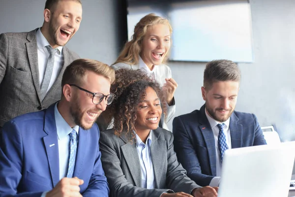행복한 비즈니스 사람들은 사무실에서 노트북 근처에서 웃는다. 성공적인 팀 동료 농담과 직장에서 함께 재미를. — 스톡 사진