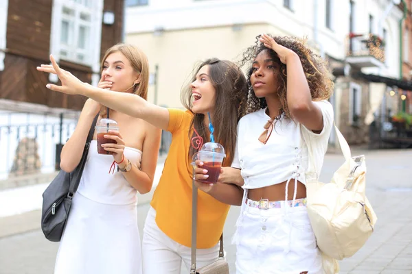 Tři trendy cool hipster dívky, přátelé pít koktejl v městském městě pozadí. — Stock fotografie