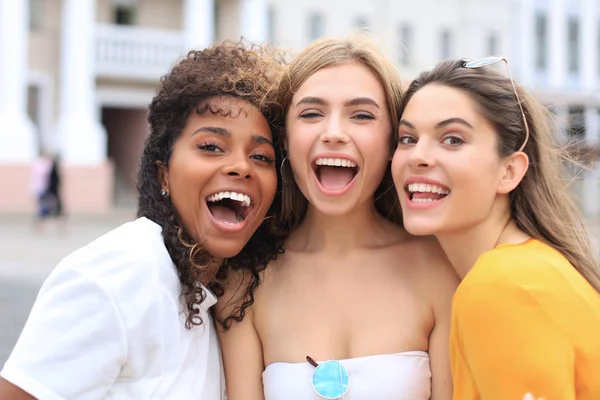 Three young smiling hipster women in summer clothes posing on street.Female showing positive face emotions. — 스톡 사진