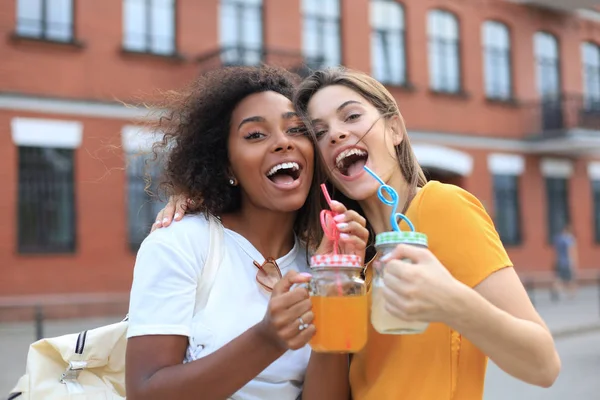 Módní cool hipster dívky, přátelé pít koktejl v městském městě pozadí. — Stock fotografie