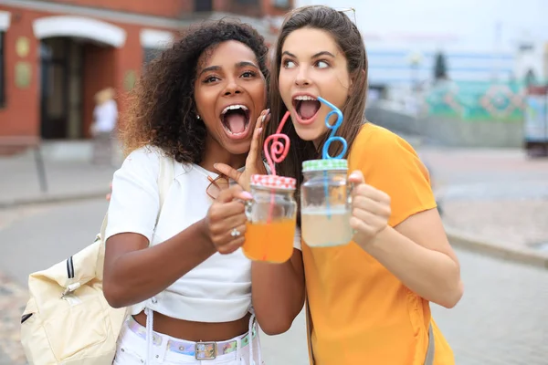 Jeunes femmes hipster souriantes en vêtements d'été posant dans la rue.Femme montrant des émotions positives au visage . — Photo