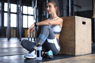 Sportif kadın dinleniyor, egzersiz yaptıktan sonra mola veriyor..