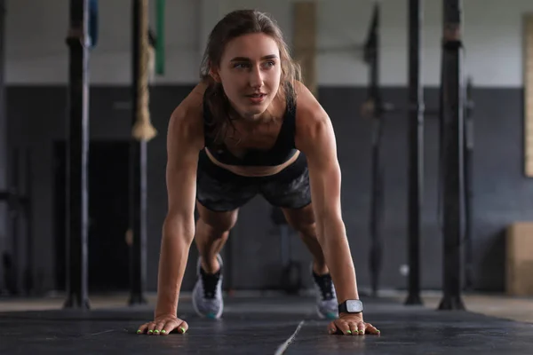 Retrato de uma mulher muscular em uma posição de prancha. — Fotografia de Stock