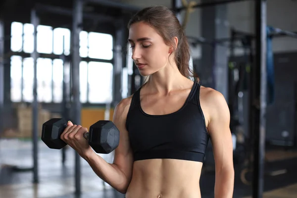 Мышечная фитнес-женщина тренирует мышцы в тренажерном зале. — стоковое фото