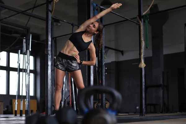 Ung sportig kvinna stretchar på gymmet. — Stockfoto