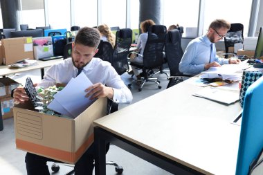 Üzgün işçi ofis malzemelerini yanında götürüyor.