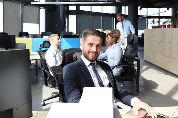 Empresario con colegas en segundo plano en la oficina moderna — Foto de Stock