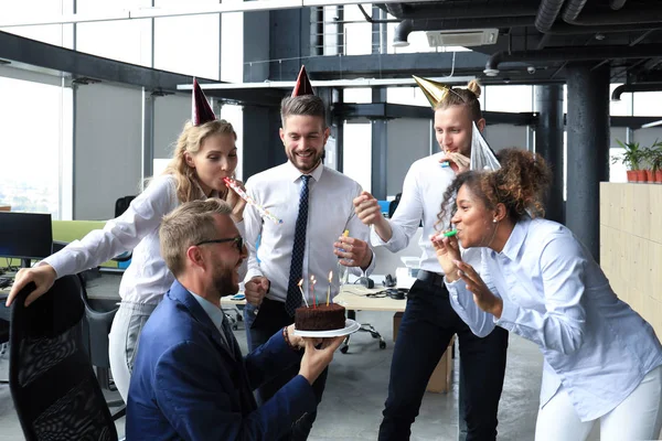 Счастливая деловая команда с праздничным тортом встречает коллегу на корпоративной вечеринке — стоковое фото