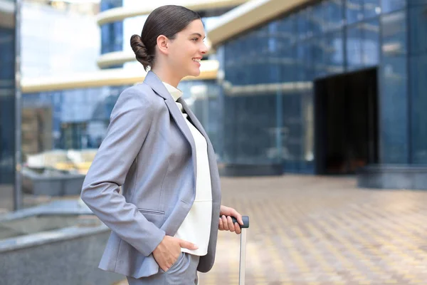 Elegant business woman with luggage in airport. Businesswoman with suitcase going to business trip. — Stock Photo, Image