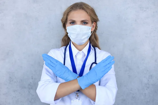 Retrato de médico feminino com estetoscópio em máscara isolado sobre fundo cinza . — Fotografia de Stock