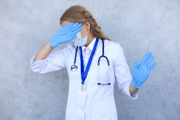 Retrato de médico feminino com estetoscópio em máscara isolado sobre fundo cinza . — Fotografia de Stock