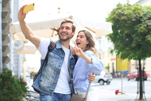 Krásný krásný mladý pár procházky na ulicích města, objímání při braní selfie. — Stock fotografie