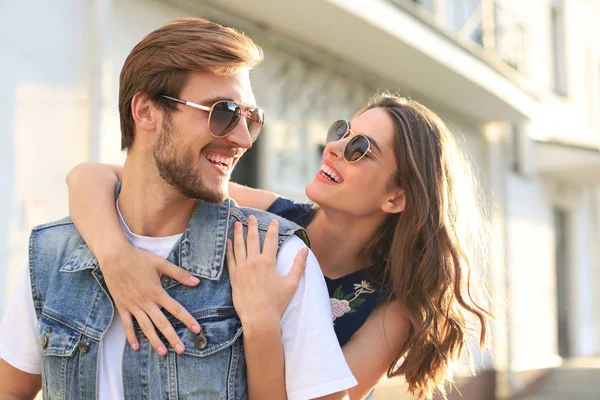 Hermosa pareja joven enamorada caminando al aire libre en la calle de la ciudad, abrazándose. — Foto de Stock