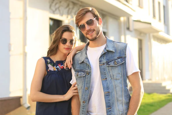 Imagen de la encantadora pareja feliz en ropa de verano sonriendo y tomados de la mano mientras caminan por la calle de la ciudad. — Foto de Stock