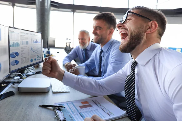 Група сучасних бізнесменів у формальному одязі посміхається і жестикулює під час роботи в офісі . — стокове фото