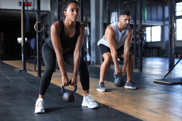 Ajuste y pareja muscular se centró en levantar una mancuerna durante una clase de ejercicio en un gimnasio. —  Fotos de Stock