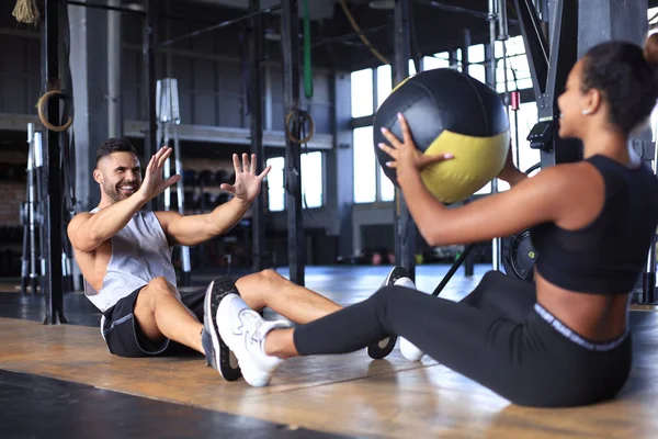 Fit and muscular couple exercising with medicine ball at gym. — Stock Photo, Image