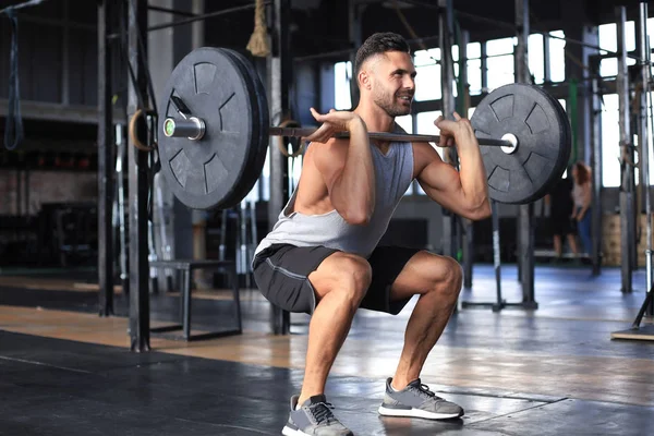 Izmos ember dolgoznak ki az edzőteremben csinál gyakorlatok súlyzó a bicepsz. — Stock Fotó