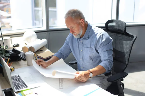 Bom olhar arquiteto maduro desenhando algo enquanto trabalhava no escritório. — Fotografia de Stock