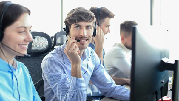 Atractivos jóvenes empresarios y colegas positivos en una oficina de call center. —  Fotos de Stock