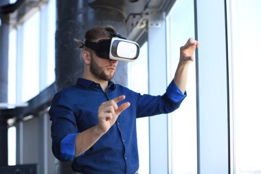 Yeni bir binada VR kulaklık takan bir mühendisin fotoğrafı. Dünyaya bakış açını ve deneyimini değiştir..