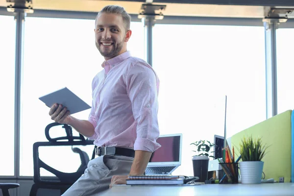 オフィスに座っている間、デジタルタブレットを使用して働いている若い現代のビジネスマン. — ストック写真