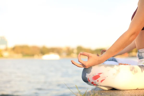 Close up hands of woman do yoga outdoor, lotus pose. Healthy and yoga concept.