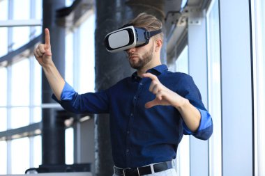 Yeni bir binada VR kulaklık takan bir mühendisin fotoğrafı. Dünyaya bakış açını ve deneyimini değiştir..