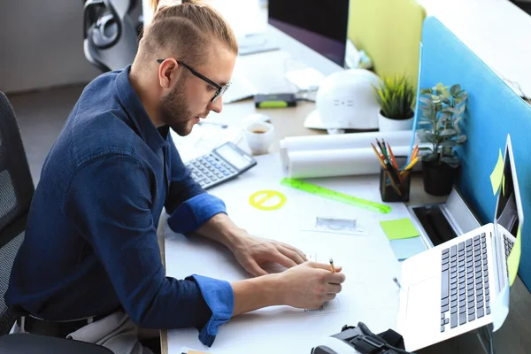 Joven empresario dibujando algo mientras trabaja en la oficina . — Foto de Stock