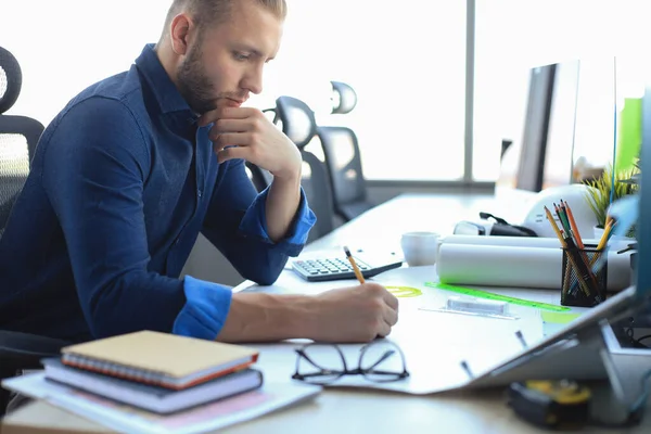 Skjuten av en stilig manlig arkitekt som arbetar med en design på sitt kontor. — Stockfoto