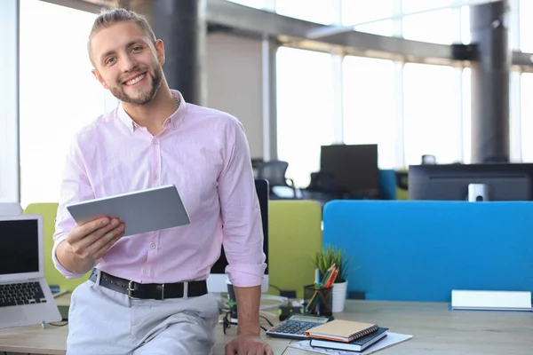 Щасливий бізнесмен працює за допомогою цифрового планшета, сидячи в офісі . — стокове фото