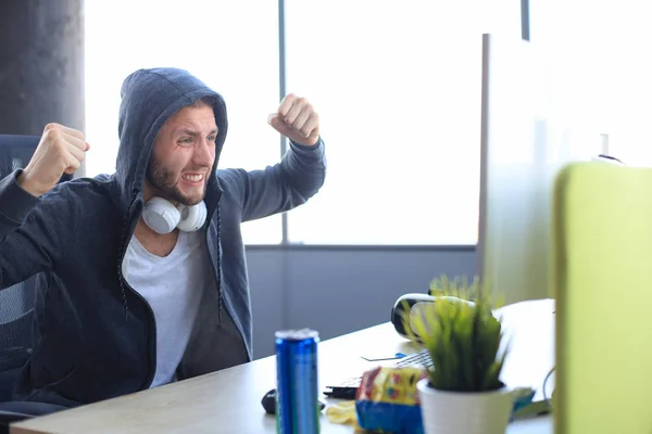 Portrait of ecstatic gamer guy in headphones screaming and rejoi