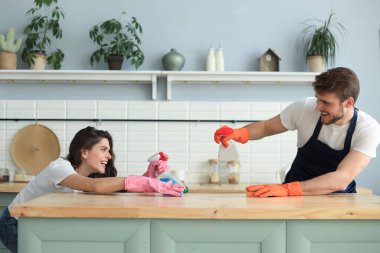 Genç mutlu çift evde temizlik yaparken eğleniyor..