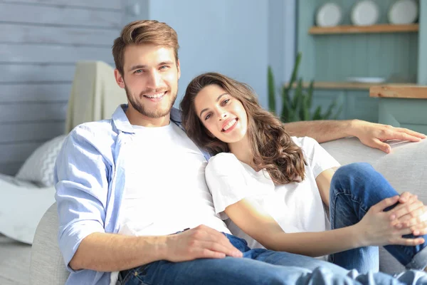Portrait of cute young couple sitting in sofa. — Stock Photo, Image