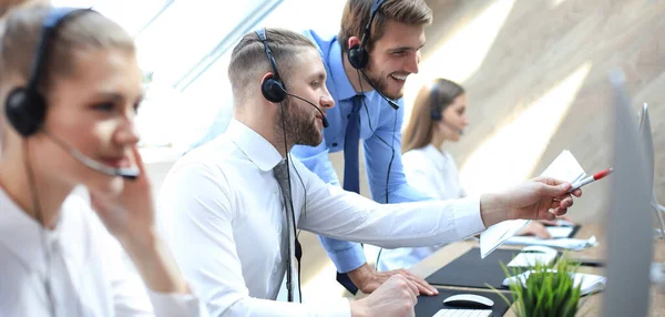 Çağrı merkezinde çalışan bir telefon operatörü meslektaşına yardım ediyor.. — Stok fotoğraf