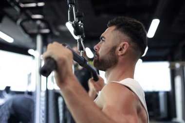 Fit ve kaslı adam simülatör sırtını sallar. Geri görünüm
