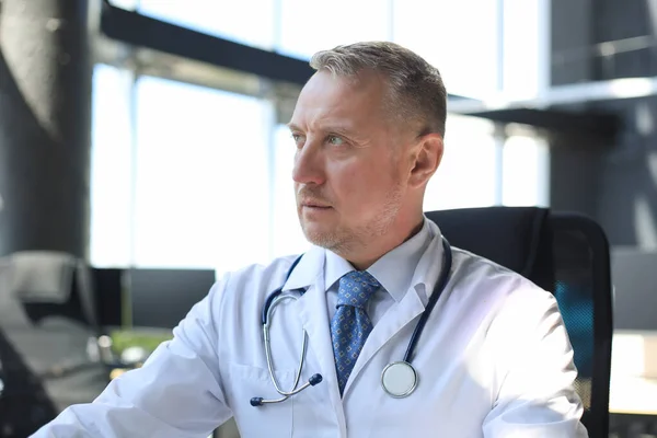 Senior chief physician in white robe with stethoscope