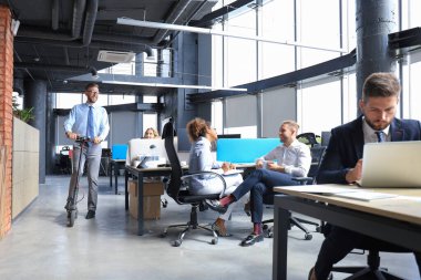 Bir grup mutlu ilerici iş adamı yaratıcı ofiste birlikte çalışıyor..