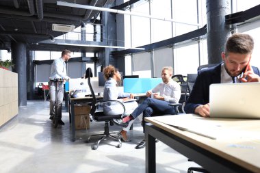 Bir grup mutlu ilerici iş adamı yaratıcı ofiste birlikte çalışıyor..