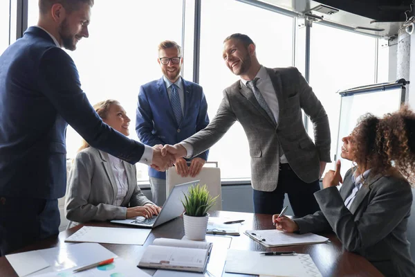 フォーマルウェアを着た若い現代のビジネスマンがオフィスで働きながら握手をし 笑顔を見せた — ストック写真