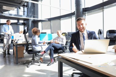 Bir grup mutlu ilerici iş adamı yaratıcı ofiste birlikte çalışıyor..