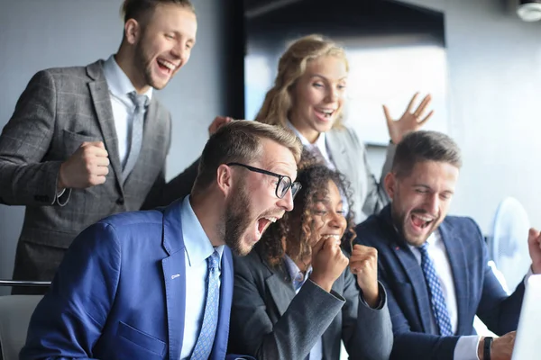 Pessoas de negócios felizes riem perto do laptop no escritório. Equipe de sucesso colegas de trabalho brincam e se divertem juntos no trabalho. — Fotografia de Stock