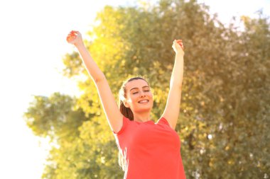Parkta aktif bir fitness eğitimi nden sonra dinlenen genç gülümseyen kadın