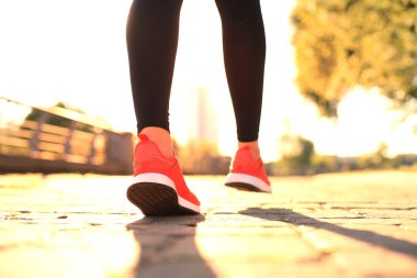 Spor ayakkabılı genç kadının açık havada egzersiz yaparken koşuya yakınlığı
