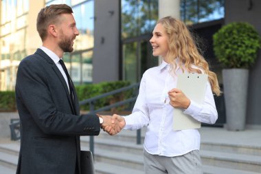 Belgeleri tartışan ve ofis yakınlarında el sıkışan meslektaşların görüntüsü