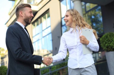 Belgeleri tartışan ve ofis yakınlarında el sıkışan meslektaşların görüntüsü