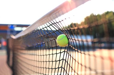 Parlak yeşilimsi sarı tenis topu ağa çarptı.