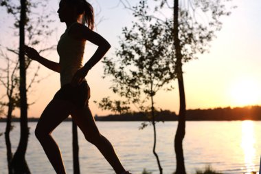 Sportif bayan koşucu doğada koşuyor ve antrenman yapıyor.