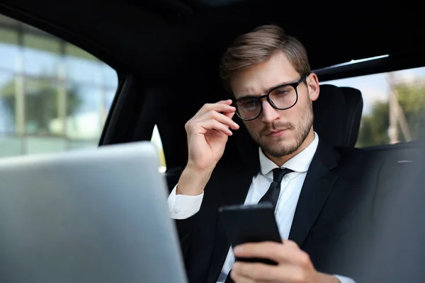 Pohledný Muž Plném Obleku Který Dívá Svůj Chytrý Telefon Když — Stock fotografie