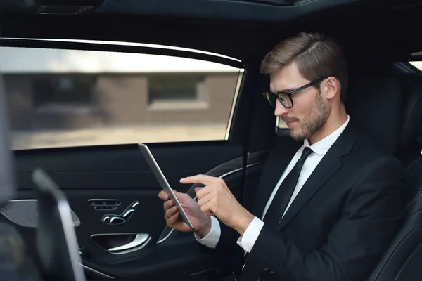 Pensativo Joven Empresario Sentado Coche Lujo Uso Tableta —  Fotos de Stock